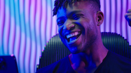 African American man guy male indoors futuristic innovation cyberspace neon lights winning with mobile phone bet casino online crypto win victory champion celebrate yelling happy video game addictの写真素材