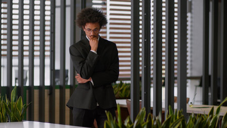 Pensive thoughtful puzzled thinking African American businessman employer developer employer business man male guy walk going walking in office ponder plan search decision solution think problem worryの写真素材
