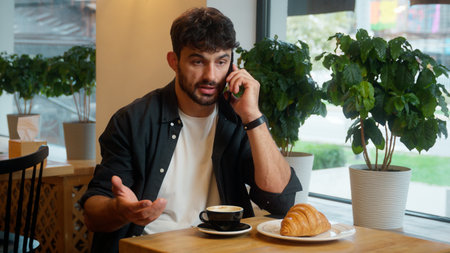 Angry nervous Caucasian man talking mobile phone cellphone quarrel arguing shout call conversation problem scream male mad guy businessman conflict cafe restaurant visitor business drink coffee indoorの写真素材