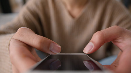 Cropped shot woman using mobile phone touch screen scrolling browsing internet app gadget addicted...