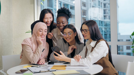 Joyful friendly group multiethnic women females diversity team five girls coworkers businesswomen business colleagues taking selfie using mobile phone smartphone photo together in office meeting roomの写真素材