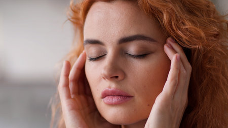 Close up ill sick painful migraine suffer Caucasian woman lady girl indoors at home female health problem trouble medicine painkiller headache massage temples head pain ache symptom hangover pressureの写真素材