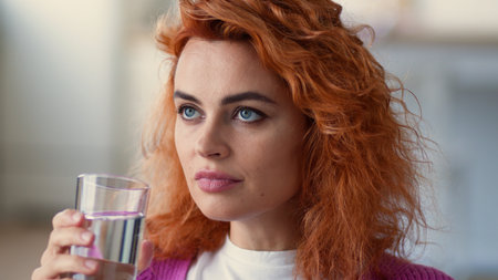 Close up smiling healthy happy Caucasian woman lady girl indoors at home female refresh hydrate drinking water hold glass drink beverage clean still aqua delivery health good habit diet detox slimmingの写真素材