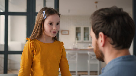 Caring Caucasian adult man father guy dad touching calm down glad preteen girl schoolgirl child at home childcare little daughter smile kid speaking parent male showing love family discussion bondingの写真素材