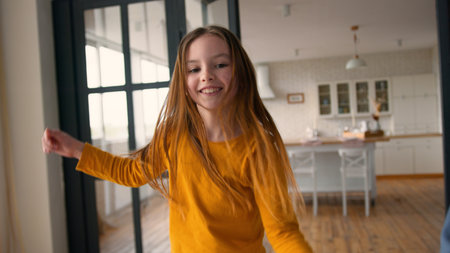 Noisy carefree joyful Caucasian family child smile girl dancing to music parent man male laugh moving father kid having fun at home dad guy celebrate little daughter schoolgirl enjoy holiday togetherの写真素材