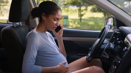 Pregnant African American woman girl car driver automobile auto belly talk mobile phone female call pregnancy painful ill health medicine unhealthy future mother ache smartphone vehicle sick transportの写真素材