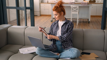 Caucasian woman homeowner girl female at home couch using laptop typing computer check payments bills analyze expenses family budget manage personal money finances loan credit bank mortgage online payの写真素材