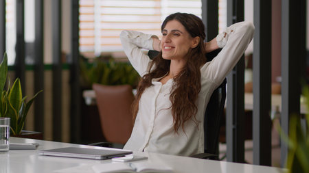 Caucasian businesswoman female boss employer business worker in office satisfied happy girl woman complete finish online work at office end close laptop rest relax on chair put hands behind head smileの写真素材