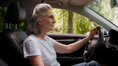 Happy smiling Caucasian mature senior elderly woman female auto owner lady grandmother automobile...
