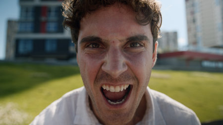 Close up angry Caucasian man male mad shouting at camera guy screaming stress city negative emotions anger face aggressive furious scream irritation problem shout yell rage outside crazy distraughtの写真素材