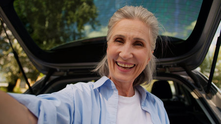 Happy cheerful aged Caucasian grandmother woman female senior car auto driver mature lady vlogger...
