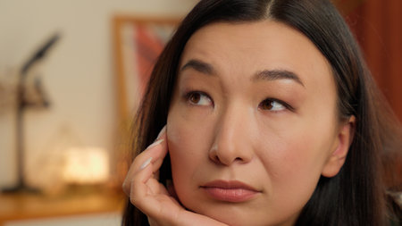 Close up thoughtful Asian woman bored girl millennial lady portrait face pensive alone sad upset female thinking home indoors frustrated dreamingの写真素材