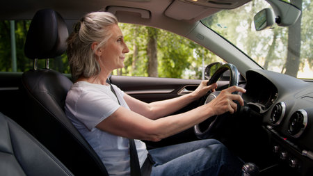 Curious Caucasian woman lady senior mature aged female rental service client car driver inside...