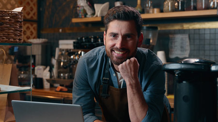 Carefree Caucasian entrepreneur barista worker browsing Internet using laptop online shopping...
