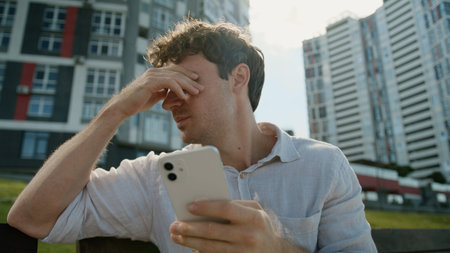 Caucasian man mobile phone smartphone error problem broken businessman male business guy disappointed stressed lost failure frustrated bad news cellphone outdoor gadget upset city internet low batteryの写真素材