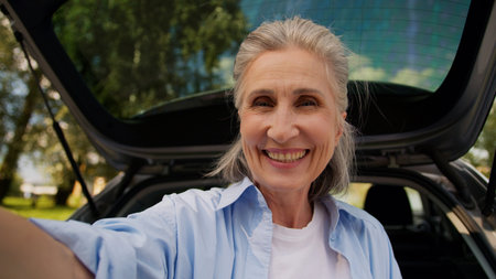 Happy cheerful aged Caucasian grandmother woman female senior car auto driver mature lady vlogger...