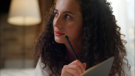Thoughtful dreaming young woman write notes in bed Caucasian girl student noting thoughts in diary...