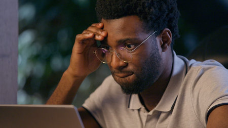 Stressed businessman African American business man in office deadline difficult job problem laptop...