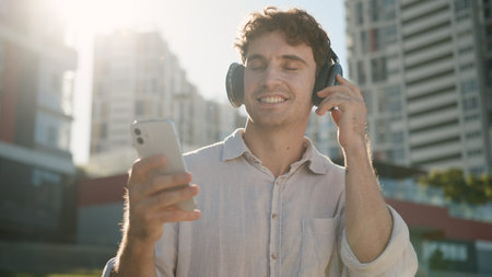 Happy Caucasian man smiling enjoyment listening music headphones earphones electronic gadget device...