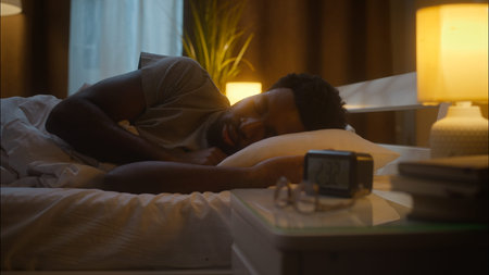 Irritated disturbed ethnic African American man male guy sleeping lying down bed napping waking...