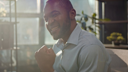 Mature African American business man winning laptop work ethnic middle-aged businessman worker salesman at sunny office sun light job with computer online champion bet celebrate triumph yes gestureの写真素材