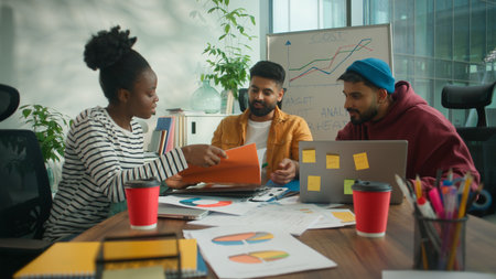 Three business workers team briefing meeting office discuss documents result stats with laptop solving financial budget company problem. Smiling African American informal businesswoman with Hindu menの写真素材