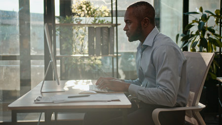 Silhouette of excited happy business man African American businessman winning online with laptop victory entrepreneur reading good news on computer achievement company CEO in sunny office sunlightの写真素材