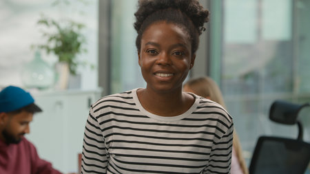 Portrait carefree positive African American ethnic business woman posing in office looking at camera Informal businesswoman female girl manager project startup owner near multiethnic coworkers workの写真素材