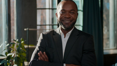 Portrait happy confident African American business man crossed hands posing smiling toothy positive joyful ethnic businessman mature male company CEO startup owner executive in sunny office smileの写真素材