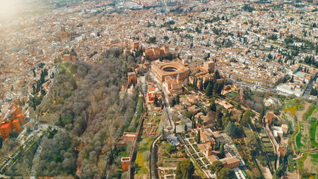 Granada Spain aerial top view of Alhambra with Palace of Charles V circular courtyard historic Andalusian fortress royal gardens surrounded by city rooftops cultural heritage landscape travel tourの写真素材