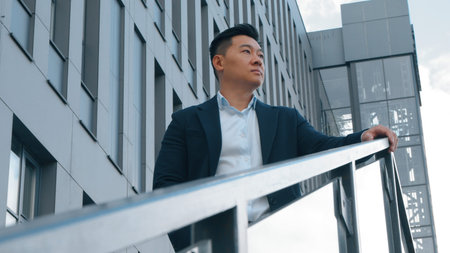 Asian middle-aged business man pensive in city near office building serious Japanese businessman...