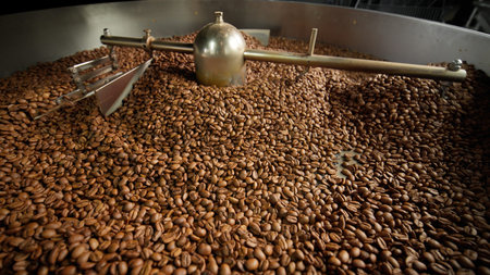 Fresh roasted coffee beans cooling in large industrial mixer machine roaster blend at modern factory...