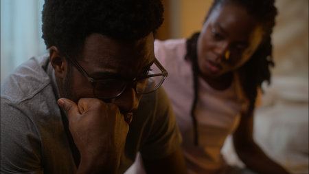 Family support African American ethnic married couple relationship problems caring woman wife apologizing after fight ask forgiveness quarrel calming depressed husband man at home bedroom late eveningの写真素材