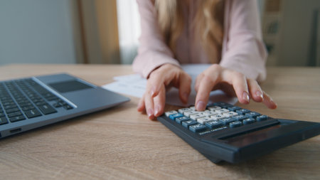 Close-up unrecognizable business woman in office with papers calculating finance company budget unknown female girl businesswoman working with laptop typing computer managing documents bills paymentsの写真素材