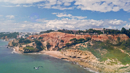 Aerial drone shot of Algarve resort historical province cliffs hills mountains exploring caves of Lagos South of Portugal travel adventure coastline Atlantic Ocean sandy beach clear blue water natureの写真素材