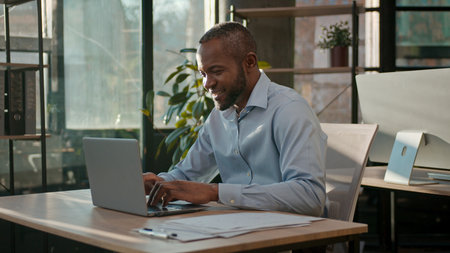 African American 40s business man typing laptop web service cyberspace adult businessman working online at office smiling mature male executive worker manager developer with computer data programmingの写真素材