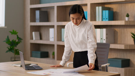 Professional Asian Japanese businesswoman female girl Korean Chinese business woman office worker secretary manager accountant analyst analyzing documents paperwork report graph project indoors roomの写真素材
