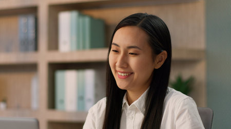 Happy laughing Asian Korean businesswoman female office worker excited amazed Japanese Chinese business woman entrepreneur looking laptop device celebrating online winning victory prize triumph indoorの写真素材