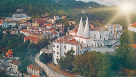 Top view of National Palace in Sintra Portugal white architect towers red rooftops in city traveling abroad vacation trip tour travel concept beautiful green hills mountains sun shining in blue skyの写真素材