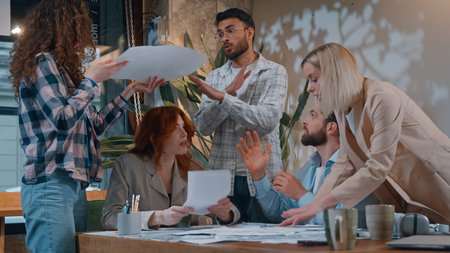 Five people feeling irritation arguing in casual informal business conference meeting throwing papers documents work team misunderstanding problem paperwork chaos Caucasian man boss leader frustratedの写真素材