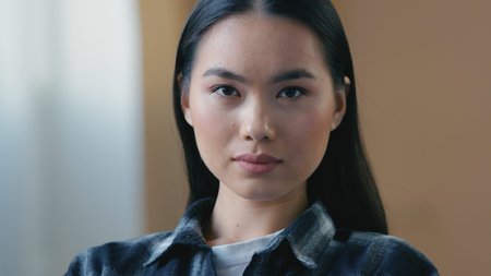 Calm serious Asian woman looking at camera smooth black hair perfect skin Korean Japanese Chinese...