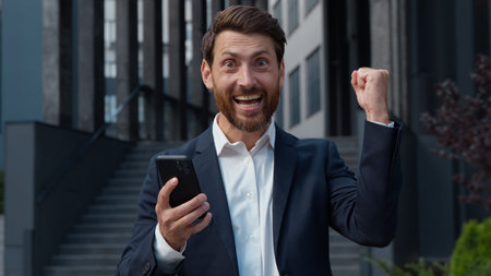 Happy carefree amazed mature Caucasian business man winning with phone mobile achievement triumph in...