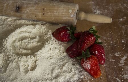 Making a cake. White flour and fresh strawberries on wooden table. Top view photo,の写真素材