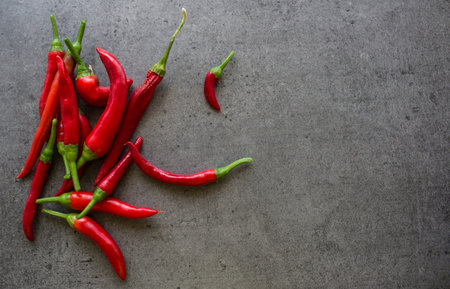 Red chili peppers on a table. Dark grey background with copy space. Ingredients top view photo....