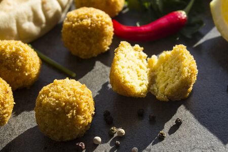 Falafel - authentic food of Israel. Fresh ingredients top view: plate of falafels, pita bread, parsley, harissa sauce, lemon, parsley and red pepper.Â  Dark grey background with copy space.Â の写真素材