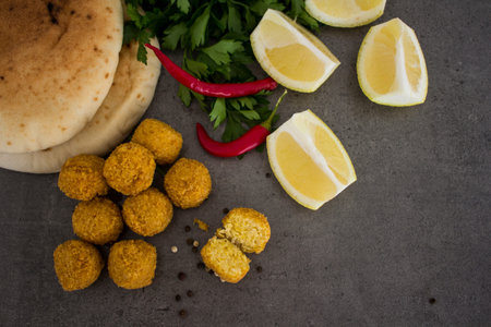 Falafel - authentic food of Israel. Fresh ingredients top view: plate of falafels, pita bread,...