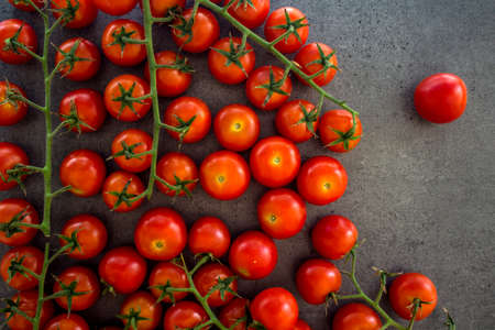 A lot of cherry tomatoes on a table. Grey background. Top view photo of fresh vegetables.の写真素材