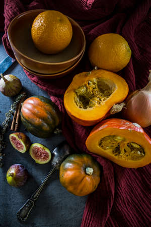 Autumn harvest. Fresh vegetables on grey table. Top view photo of butternut, gem squash, pumpkin, golden nugget, carrot, figs, sweet potato, onion, oranges and parsley. Healthy eating concept.Â の写真素材
