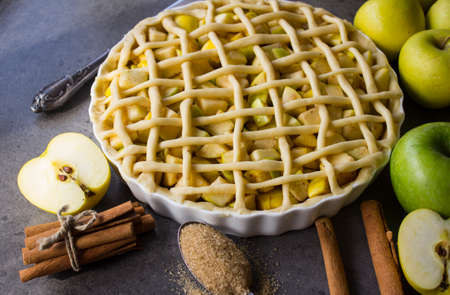 Unbaked apple pie on a table. Cakes decoration ideas.  Gray textured background.の写真素材