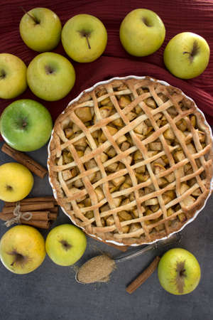 Apple pie with lattice decoration. Homemade dessert pie top view photo. Grey background.の写真素材